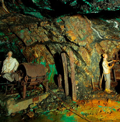 Nachbildungen arbeitender Menschen an Maschinen im Stollen.