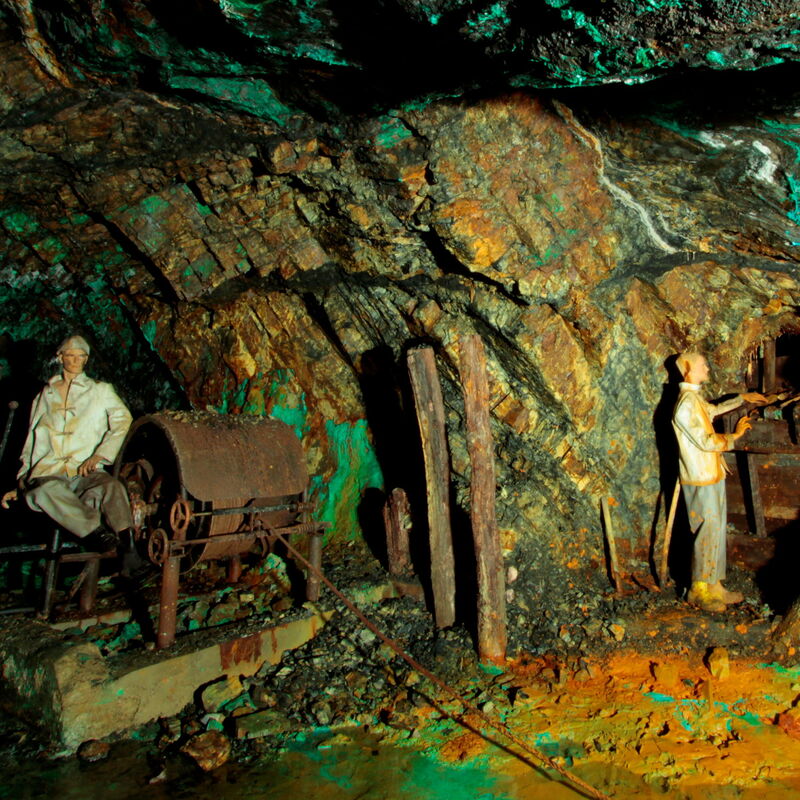 Nachbildungen arbeitender Menschen an Maschinen im Stollen.