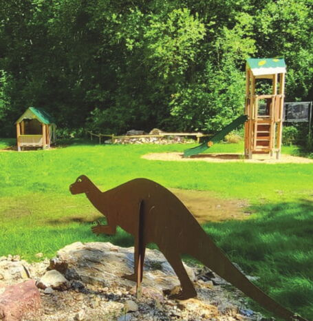 Eine Darstellung eines Iguanodonten auf einem Spielplatz.