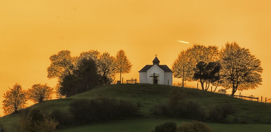 Der Kalvarienberg mit einer Kirche bei Sonnenuntergang.