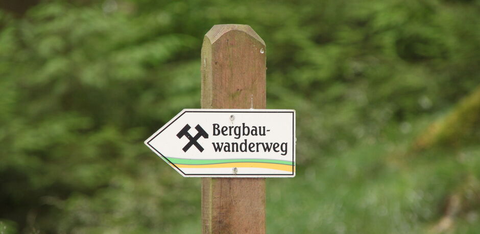 Ein Schild mit "Bergbauwanderweg" beschriftet zeigt die Laufrichtung an.