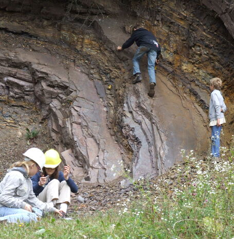 Kinder, die auf dem Steinbruch Borghagen, der sich auf dem geologischen Rundweg Düdinghausen befindet, klettern.