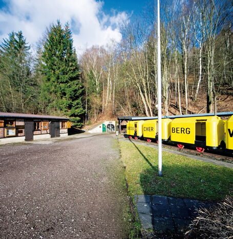Eingang des Kilianstollens in der Mitte mit Wagons auf der rechten Seite und einem Gebäude auf der linken Seite.