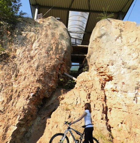 Eine Fahrradfahrerin auf einer GeoRadroute vor der Korbacher Spalte.