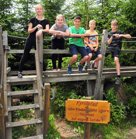 Fünf Kinder auf dem Geländer am Anfang des Kyrillpfades.